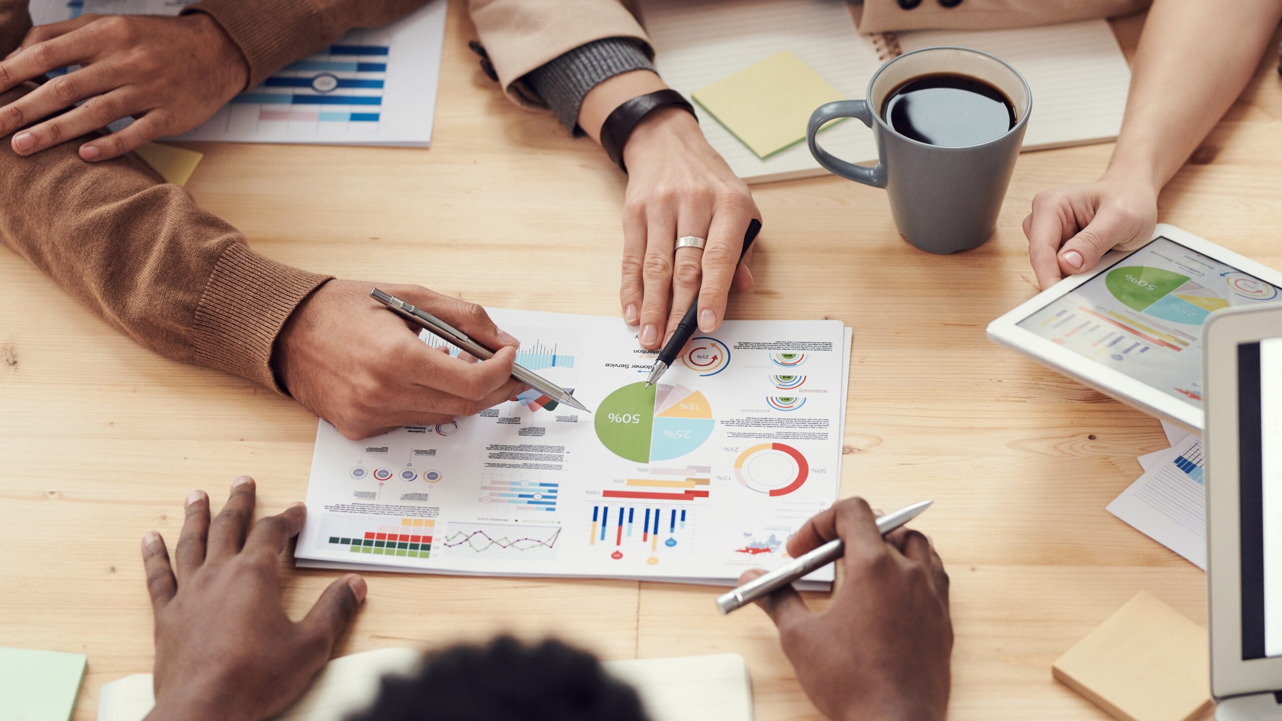 in this image there are people sitting around a table discussing a marketing strategy document print